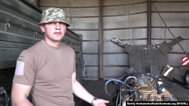 Микола, командир ремонтного взводу, біля двигуна від американської вантажівки