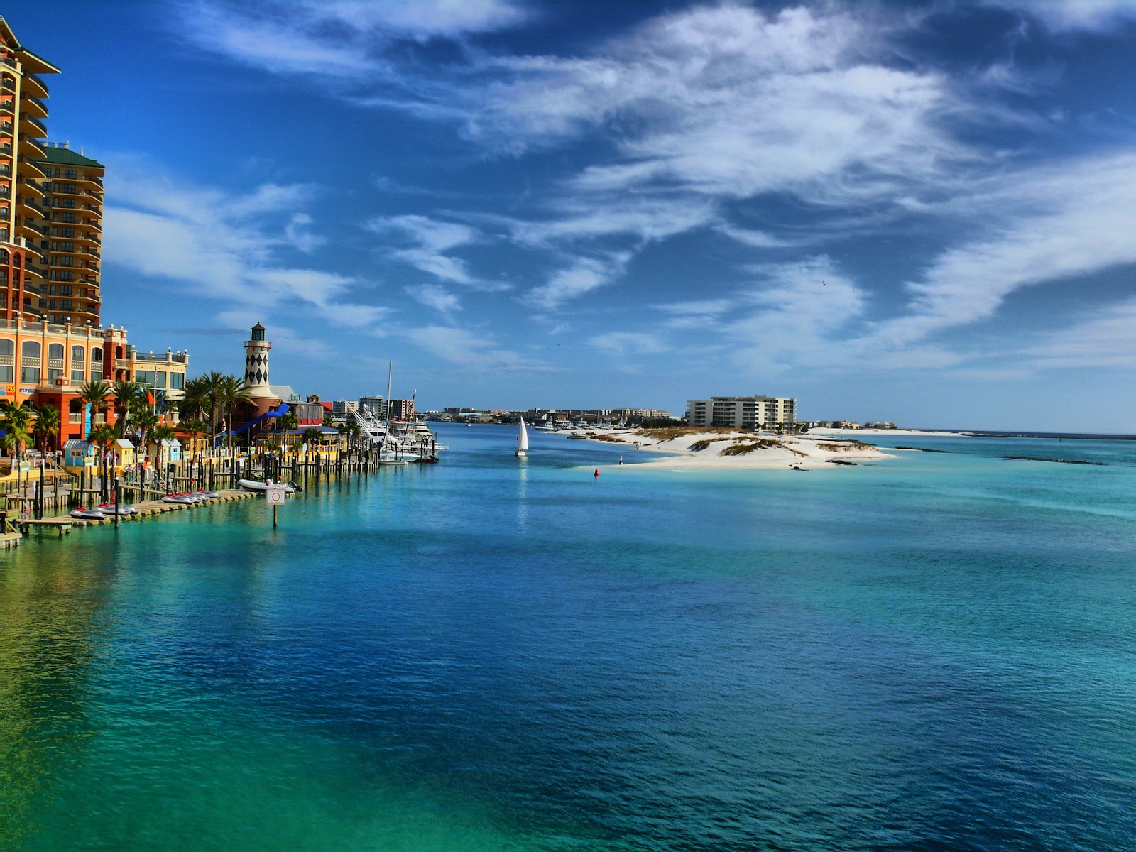 Turquoise waters with a massive hotel and palm trees.