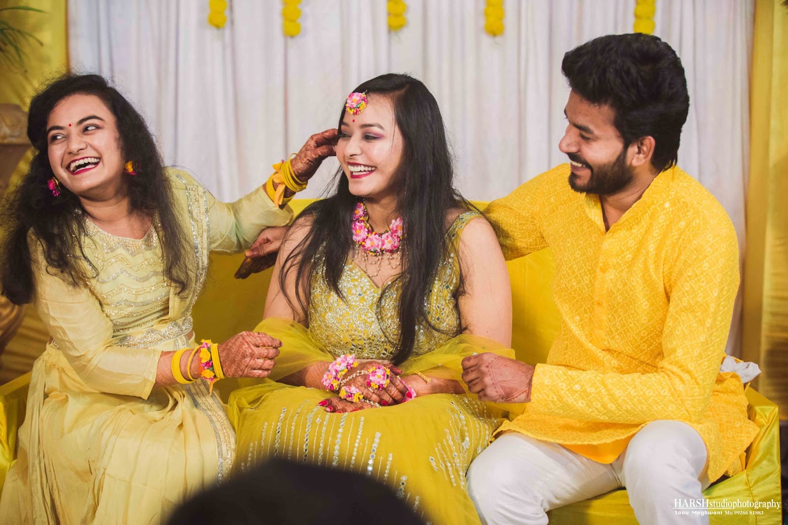 Candid image of the bride having haldi fun with her brother and sister in Indore, captured by Harsh Studio Photography in 2024. Harsh Studio Photography excels in capturing spontaneous and joyful wedding moments.