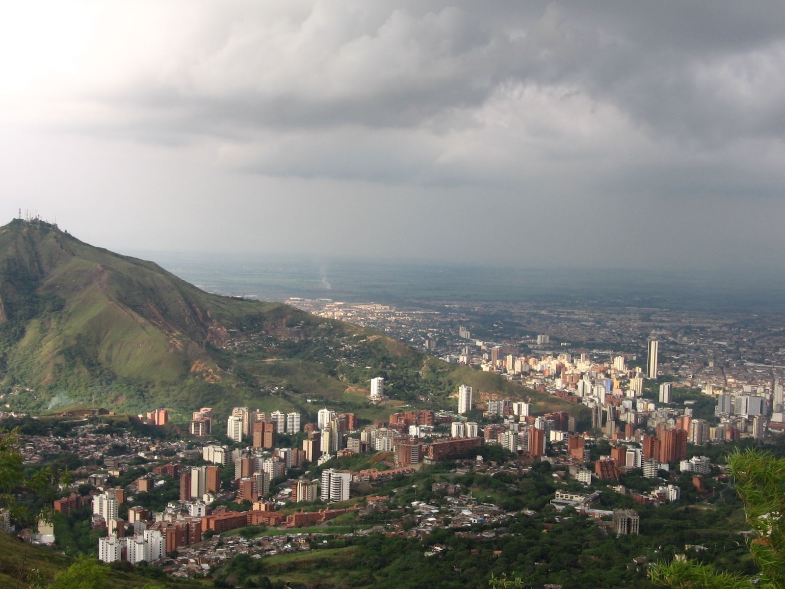 Cloudy weather over mountains with buildings at the base.