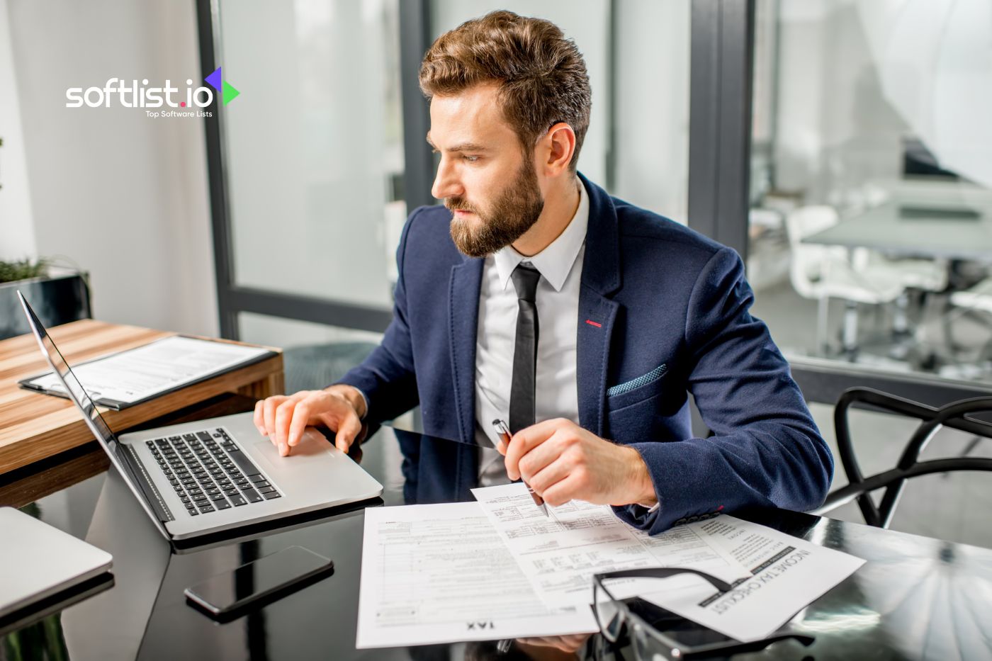 Professional using QuickBooks for tax paperwork at desk