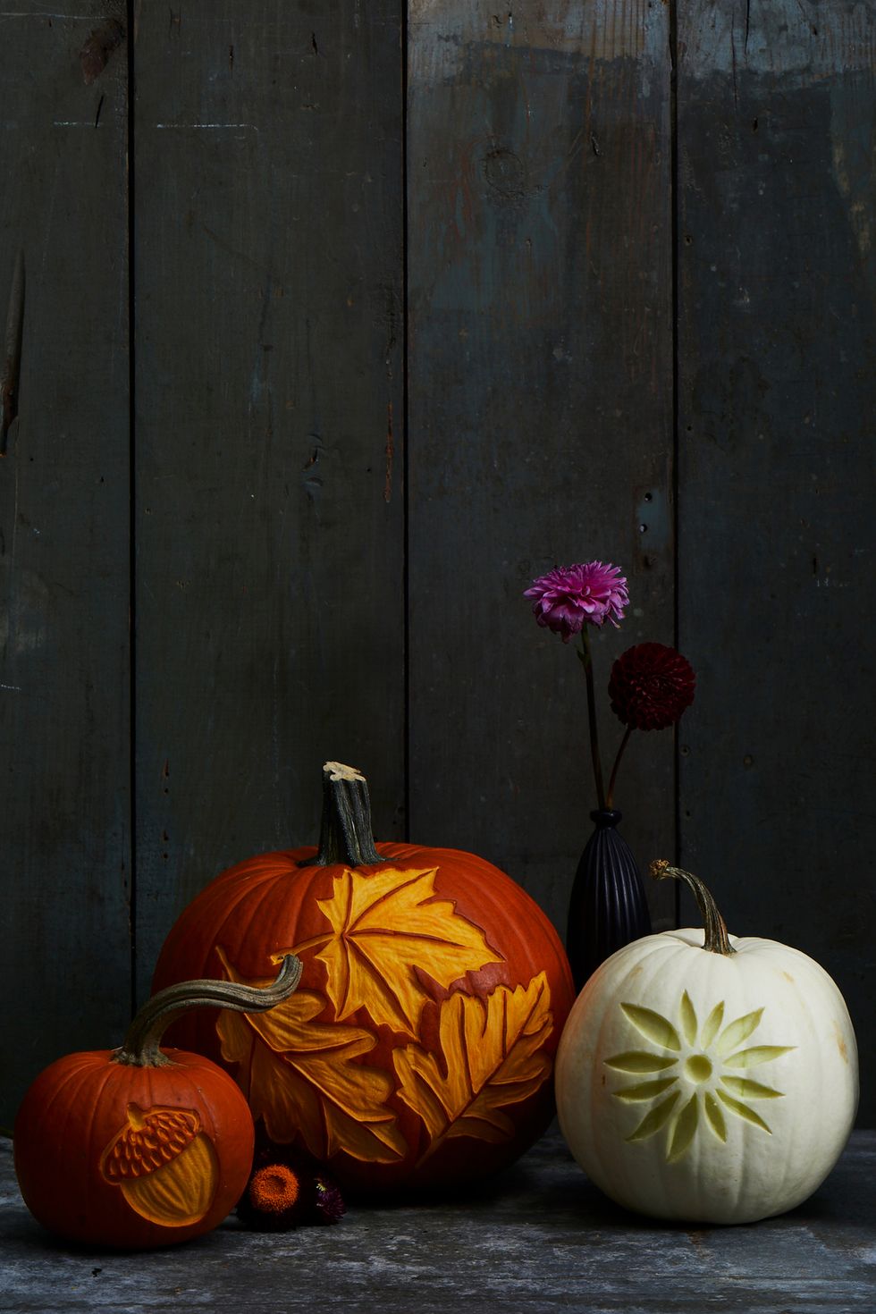 pumpkin carving ideas, three pumpkins with different designs, acorns, leaves and flowers