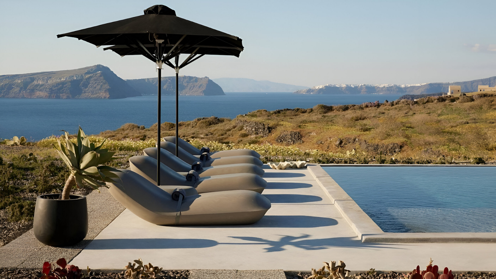 Sun loungers beside the pool of a vacation rental in Santorini.