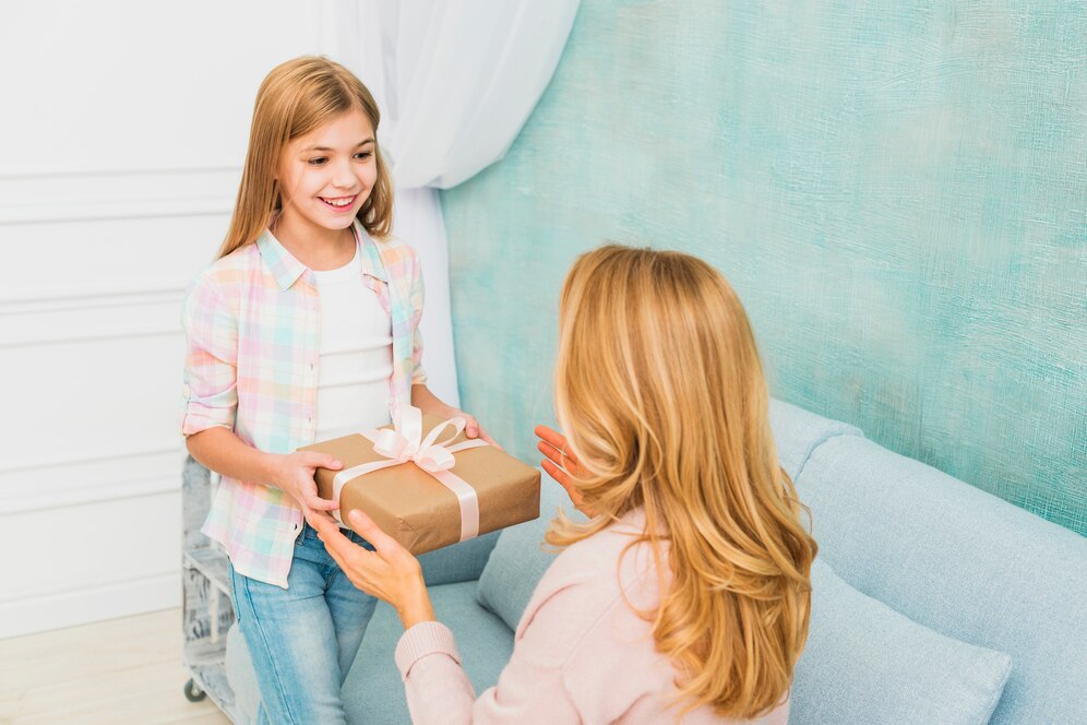 little girl giving gift to her mother