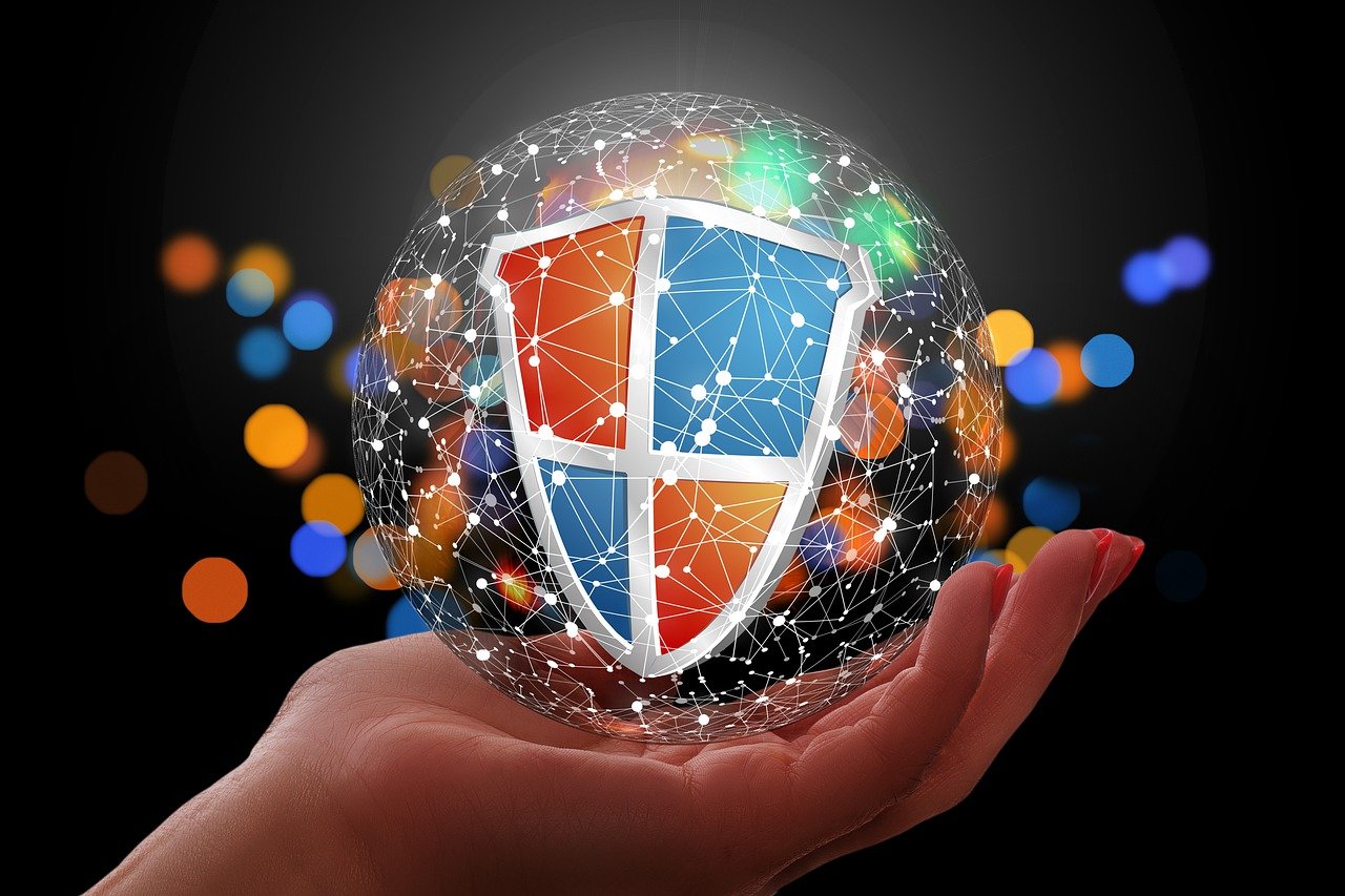 A hand holding a sphere with a shield symbol, surrounded by interconnected nodes and lines.