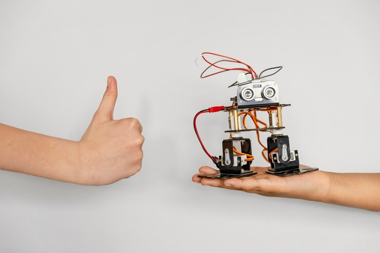 Hand with robot making an OK sign, representing STEM vs STEAM.