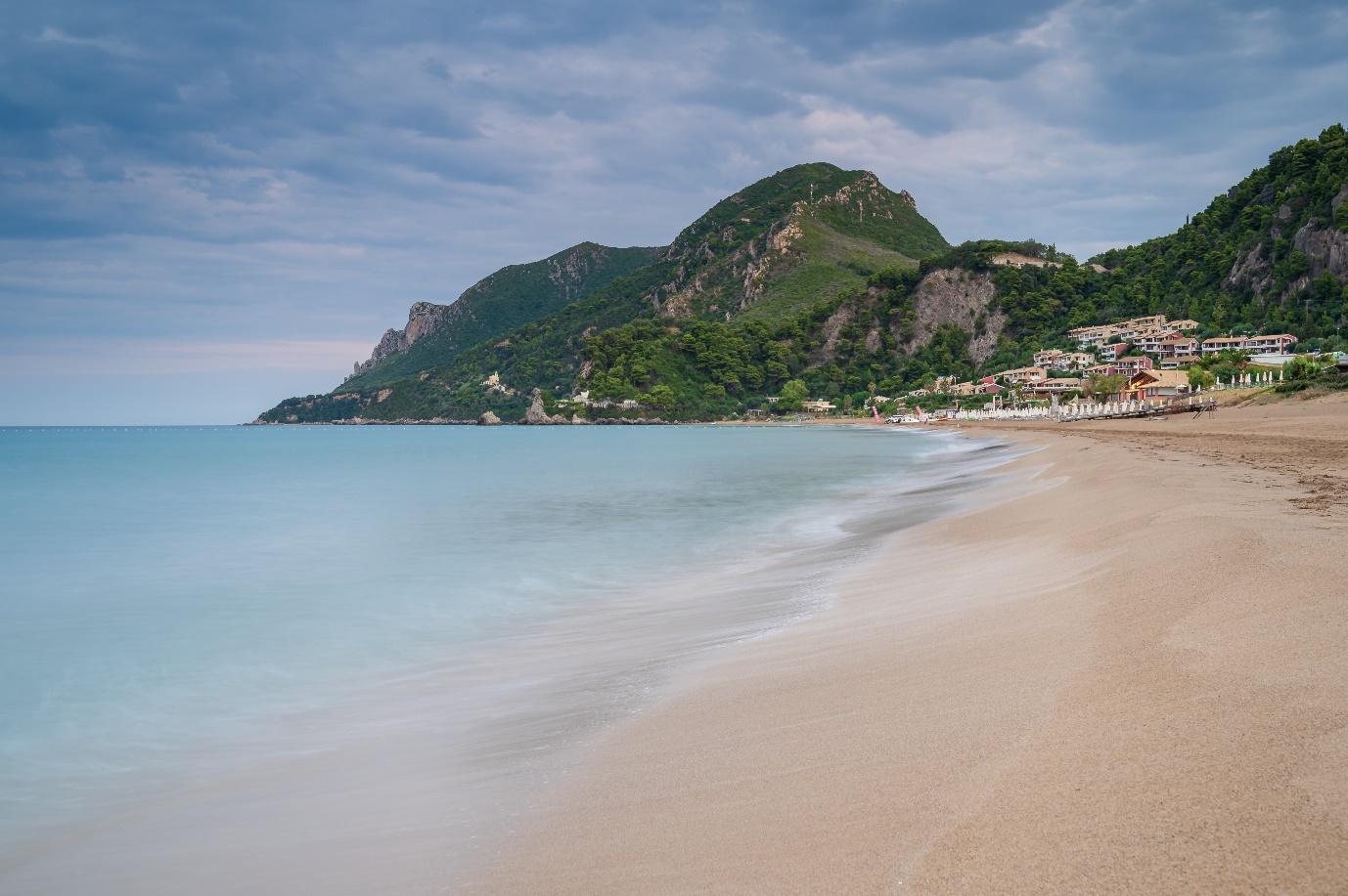 A beach with a mountain in the background

Description automatically generated