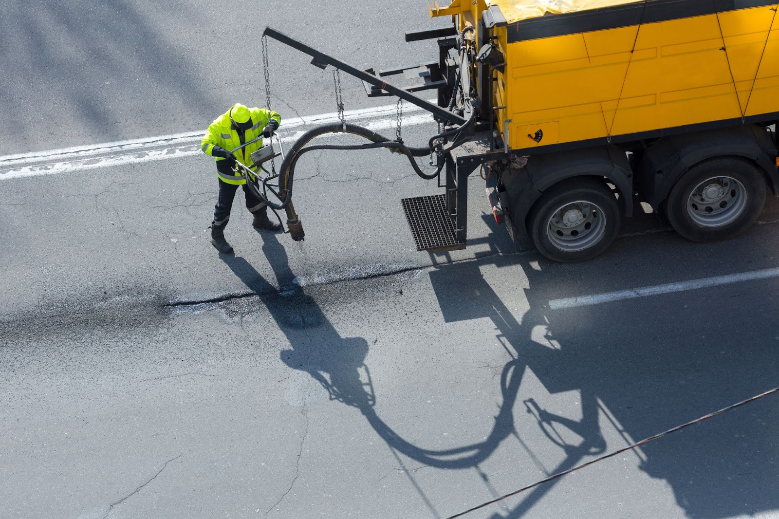 worker performs crack sealing