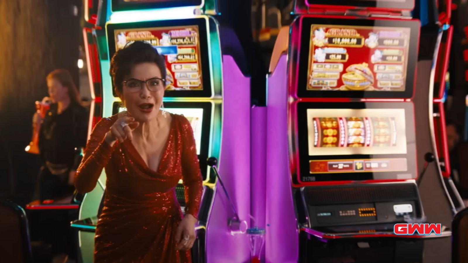 Mrs. Chen in a red dress excitedly pointing while standing by slot machines.