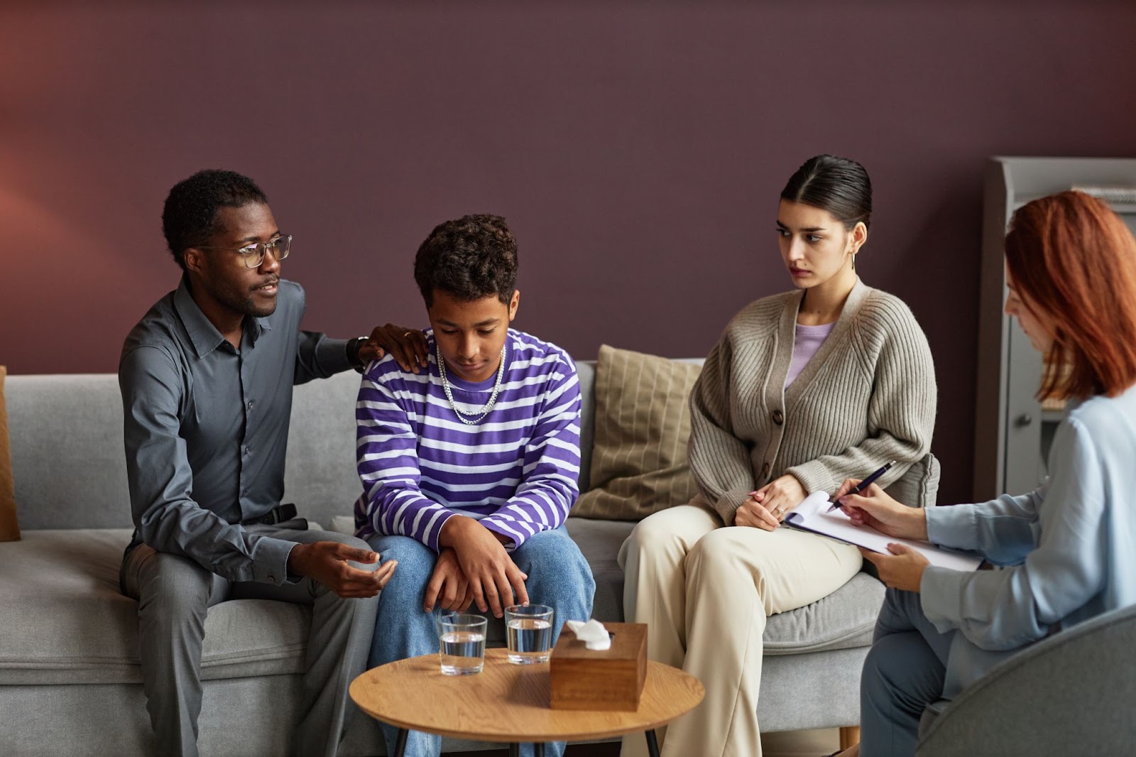 A family accompanies their son during a psychotherapy session. 