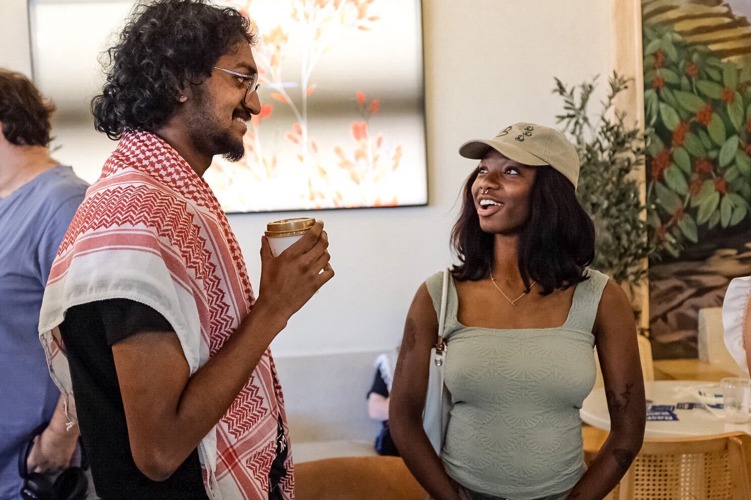 Two young people drink coffee and discuss politics