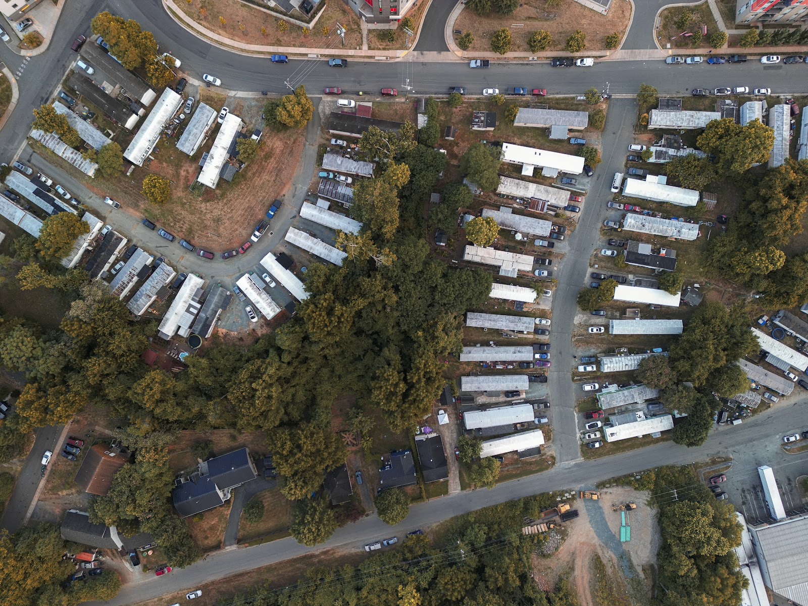 An aerial view of the mobile home park. Long trailer homes are lined up side by side along the curved roads.