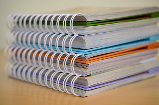 Colorful notebooks with spiral bindings arranged in a stack.