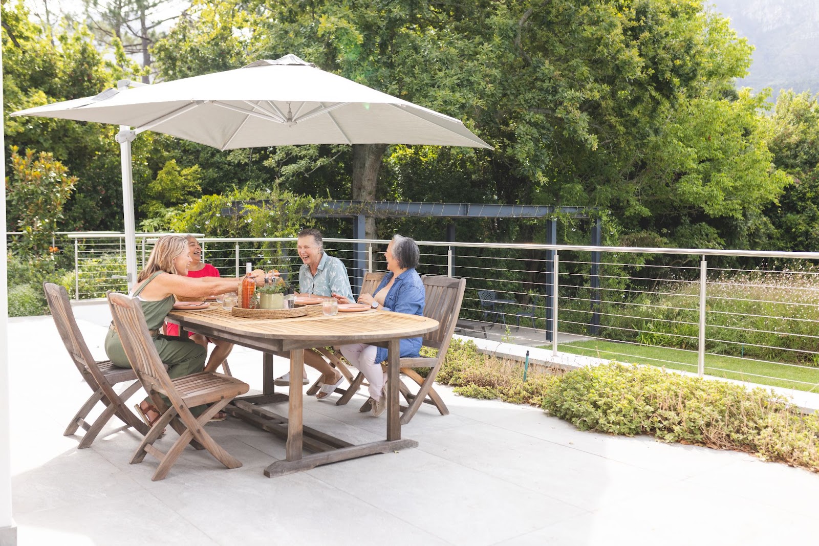 Four people sitting at a table on their patio. 