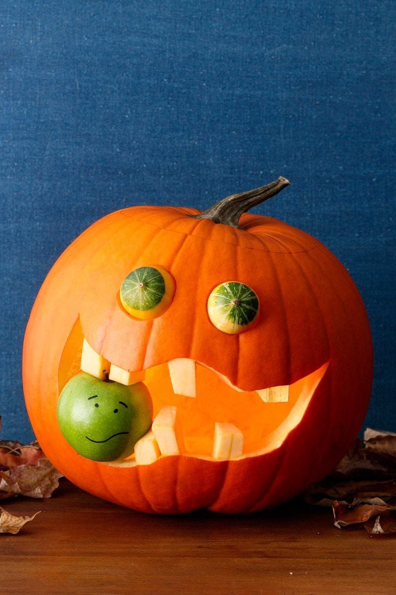 pumpkin carving ideas, carved pumpkin with squash in the eyes and an apple in the carved out mouth