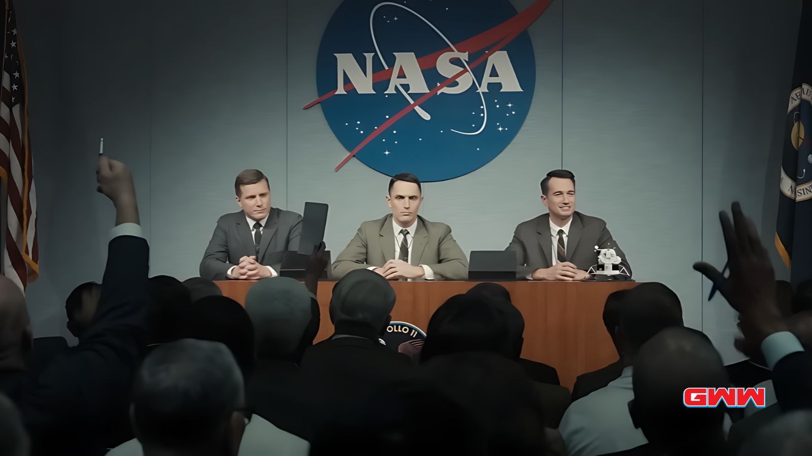 Neil, Buzz y Michael en la mesa de la conferencia de prensa de la NASA con la audiencia.