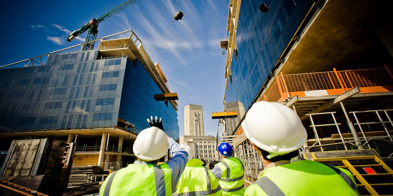 Construction workers in hardhats and safety vests on a construction site