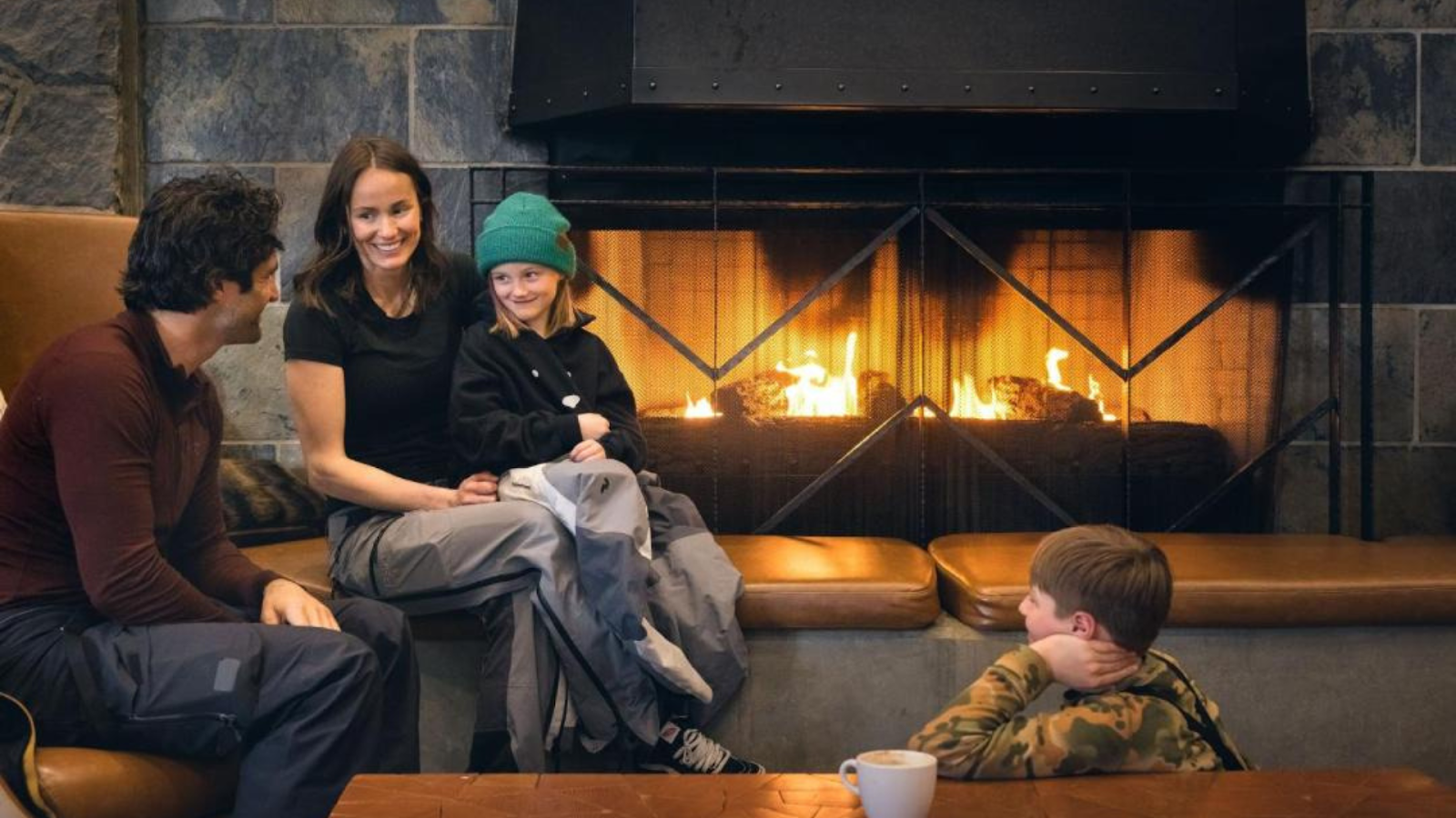 A family sitting by the fireplace of a hotel in Whistler, BC | Photo credit: The Westin Resort & Spa Whistler