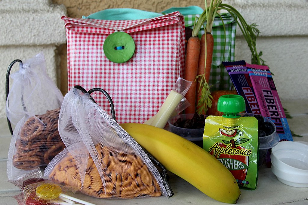 Some dry snacks, protein bars, popsicles, banana, carrots and a pack of apple sauce for healthy snacking.