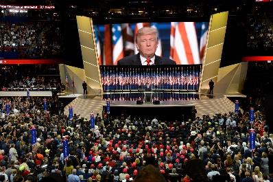 A large group of people in front of a large screen

Description automatically generated