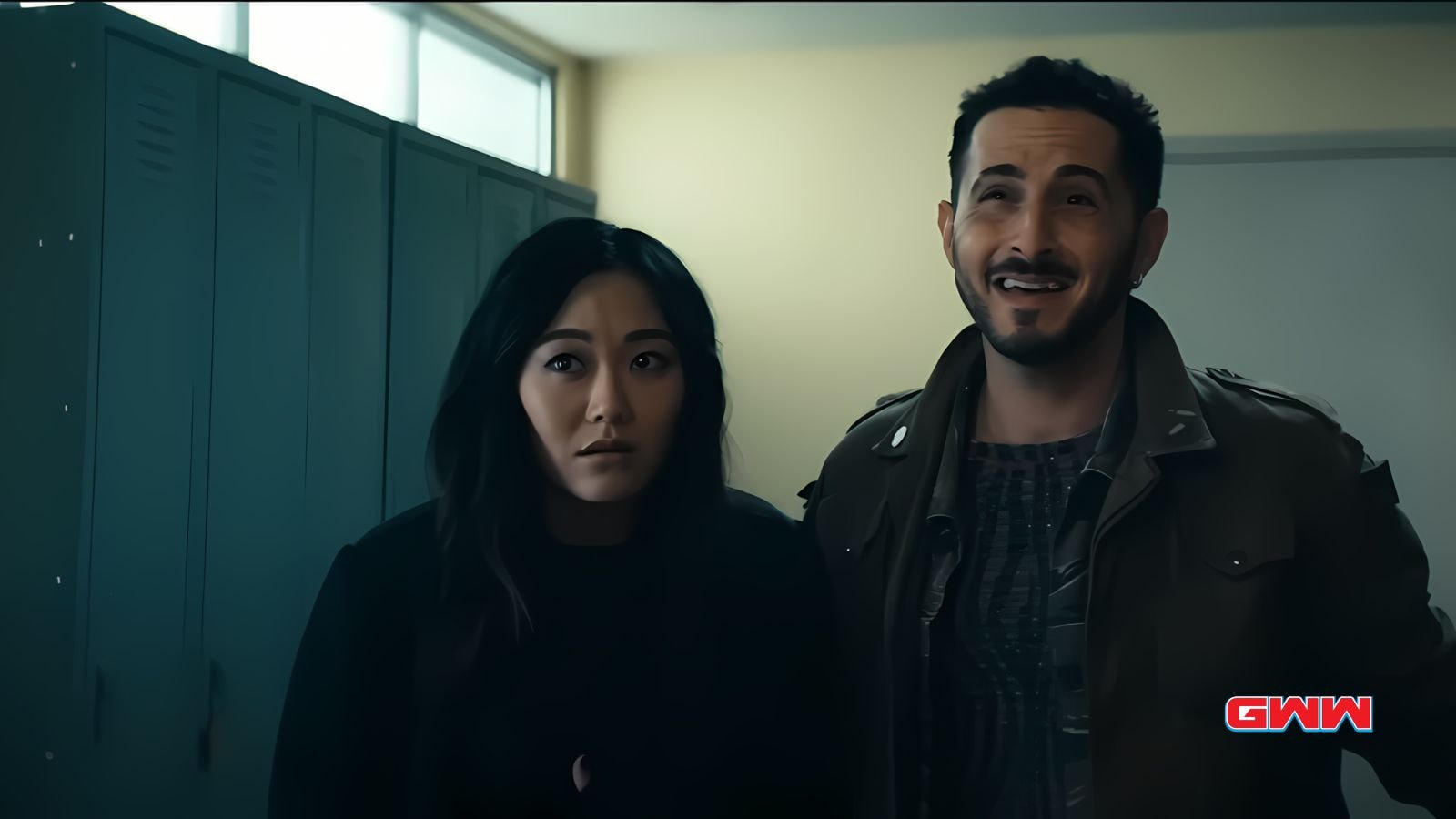 Tomer Capone as Frenchie and Karen Fukuhara as Kimiko, standing by lockers.