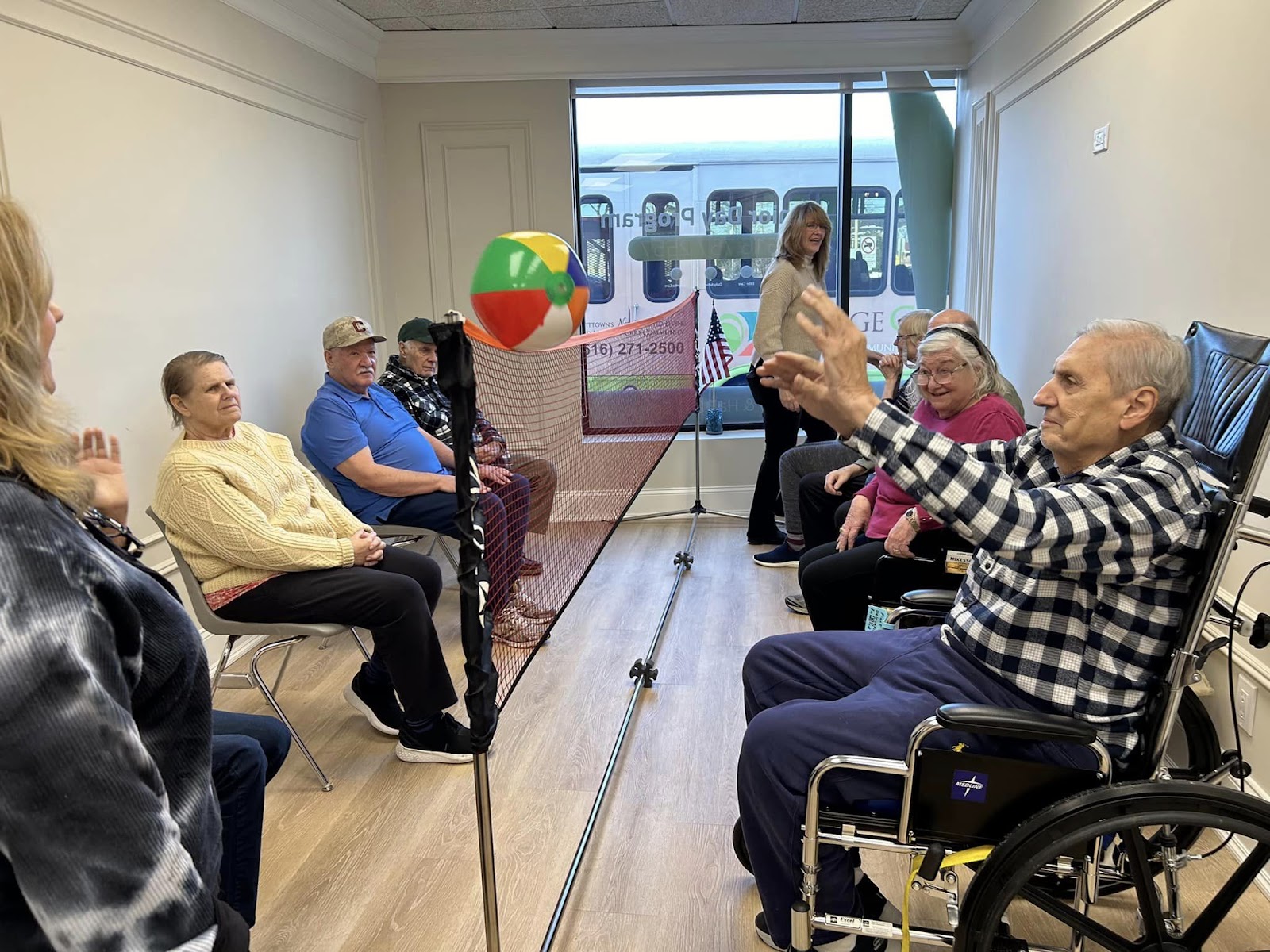 Elderly individuals in a memory care facility playing blow-up beach volleyball