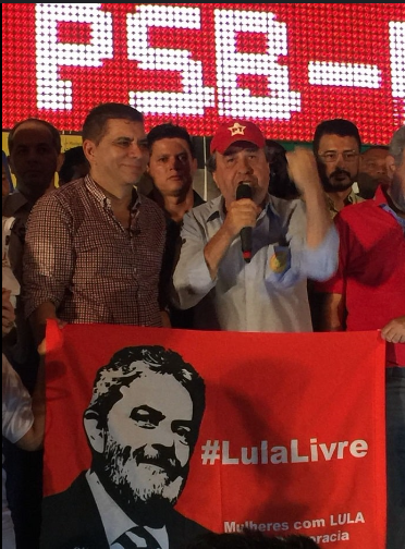 Carlos Amastha ao lado de seu vice, Célio Moura, segurando a bandeira de "Lula livre"