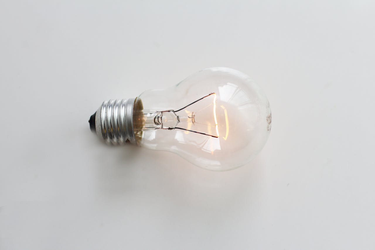 Glowing light bulb on plain white surface.