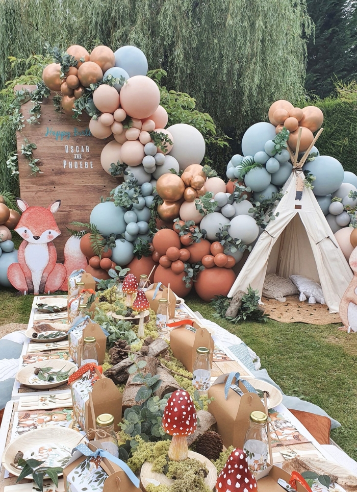 outdoor woodland baby shower with table and balloons