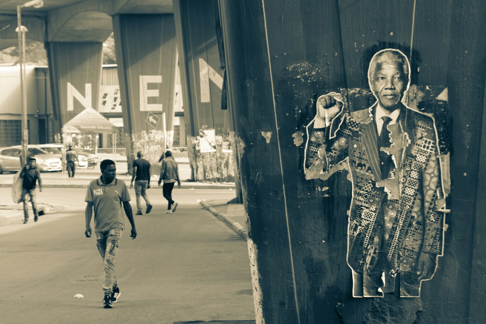 A man walking down a street in a black and white photo.