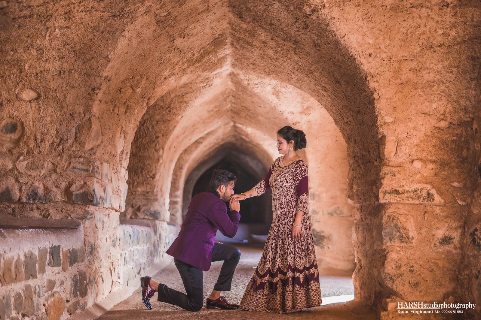 Pre-wedding shoot location in Mandu, near Indore, capturing a romantic moment as the groom kisses the bride's hand. Captured by Harsh Studio Photography, a premier wedding photographer in Indore, renowned for their exceptional services. Keywords targeted: Wedding photographer, Best wedding photographers, Wedding photography services, Professional wedding photographers, Wedding photographer near me, Affordable wedding photographers Indore, Top-rated wedding photographers, Wedding photographer availability Indore, Wedding photographer portfolio Indore, Wedding photographer rates in Indore. Harsh Studio Photography specializes in creating memorable pre-wedding moments with creativity and passion.