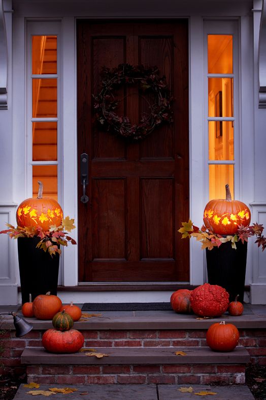 pumpkin carving ideas, two pumpkins with leaf designs on both sides of the entrance