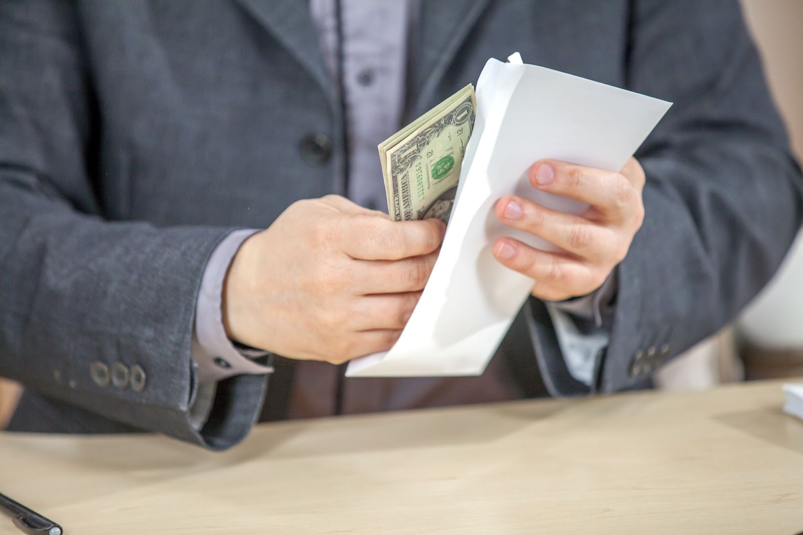 Young entrepreneur working from his office and counting cash