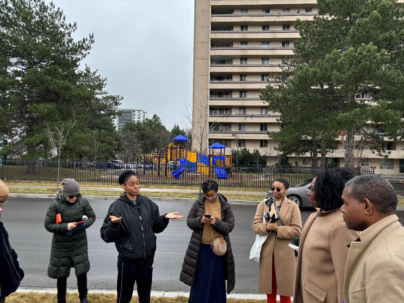 A group of people standing on a street

Description automatically generated