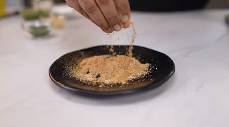 Mixing jeera powder, yellow chilli powder, coriander powder, black salt, and amchur powder in a bowl for Dahi Bhalla seasoning.