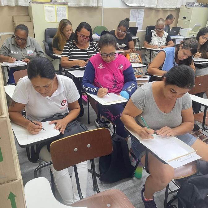 Grupo de pessoas sentadas ao redor de mesa com computador e cadeira

Descrição gerada automaticamente