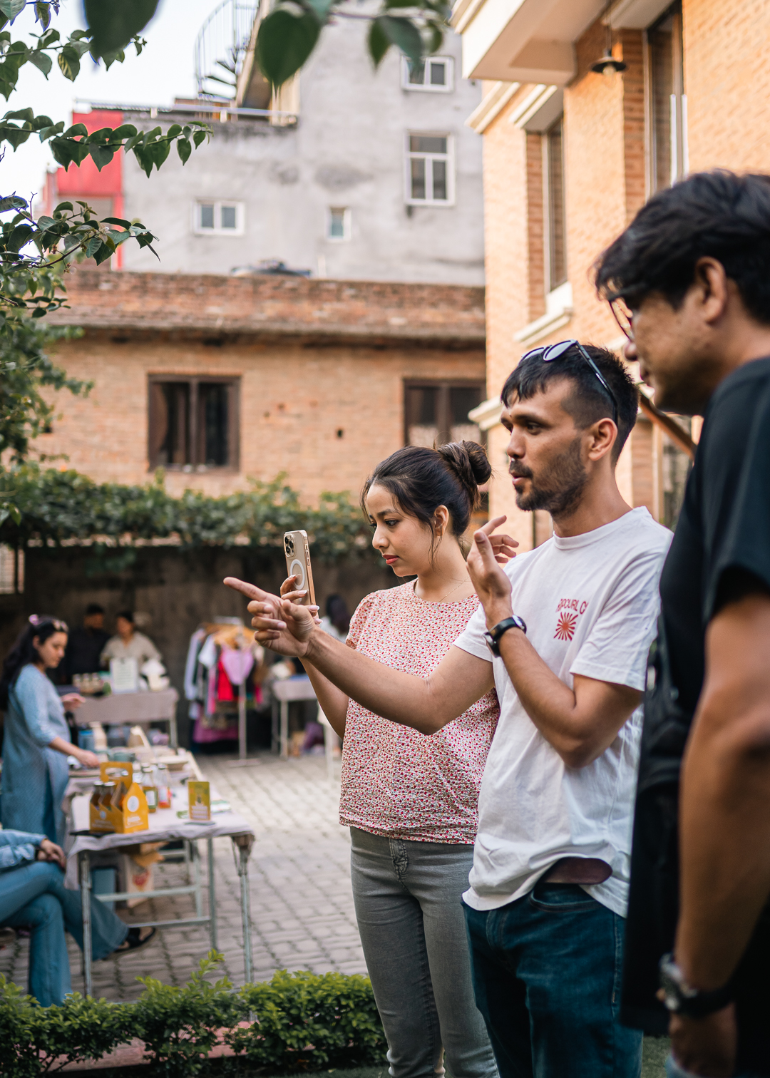 Saurav Karki, founder of Buneko Nepal, discusses the success of Nature's Market with two attendees, highlighting the event's focus on sustainability and plans for future eco-friendly initiatives.