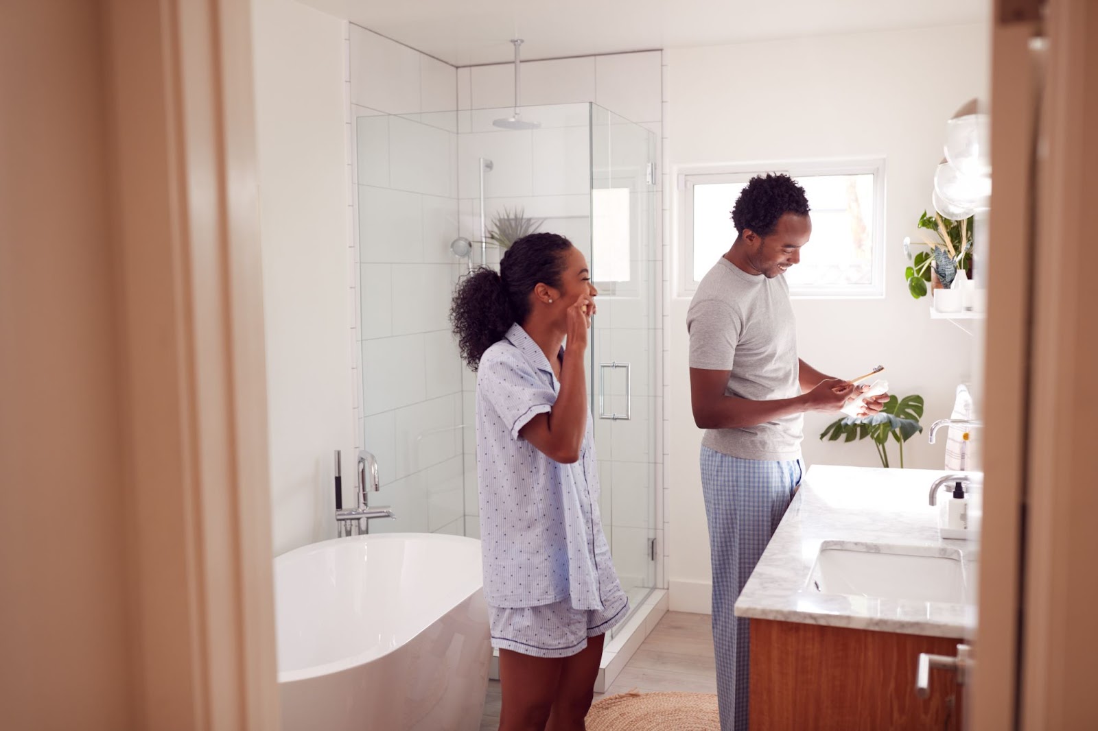 A couple brushes their teeth in their designer bathroom.