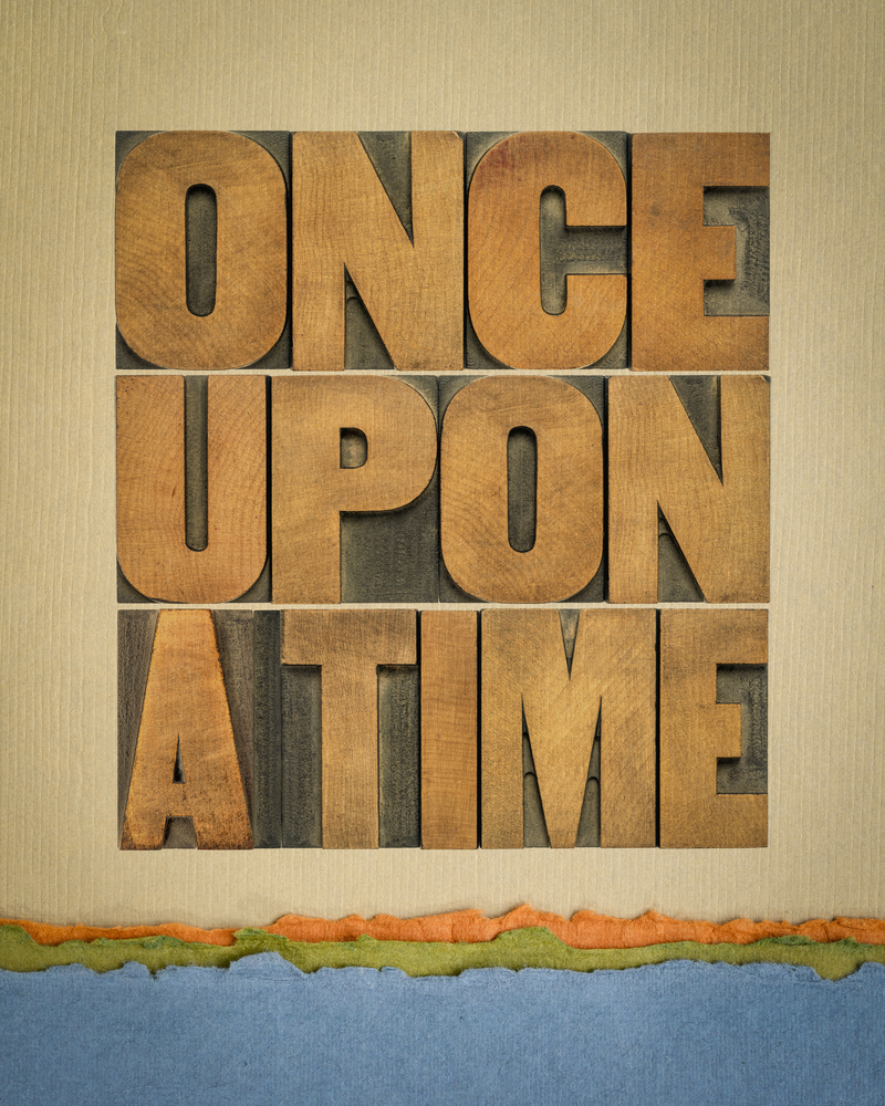 A textured graphic displaying the words "ONCE UPON A TIME" in large, wooden block letters against a beige background, with a torn paper border at the bottom, perfect for setting the scene in an Arm's Reach Show & Tell game for virtual team building.