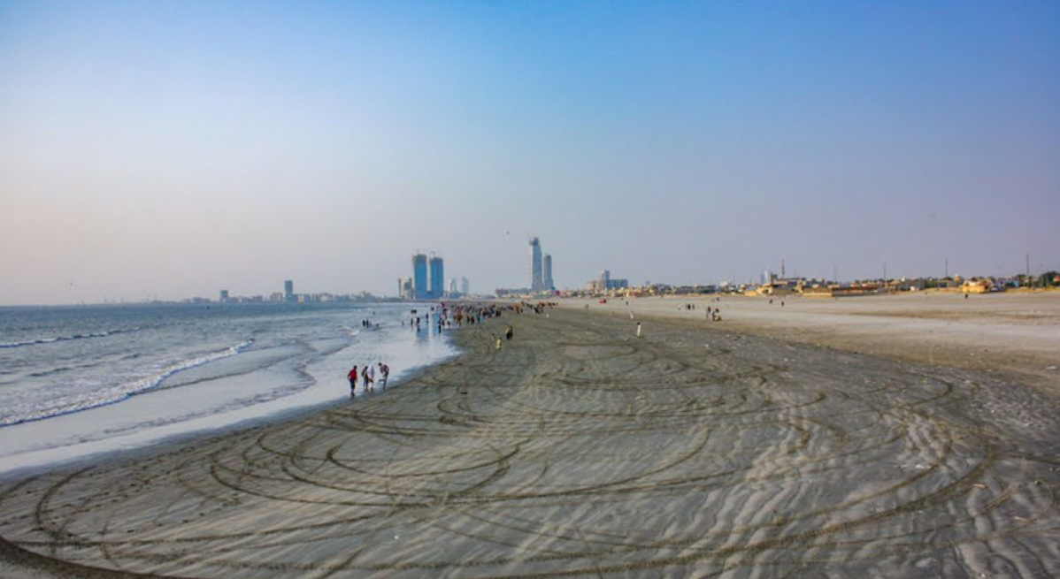 A beach with people walking on it

Description automatically generated
