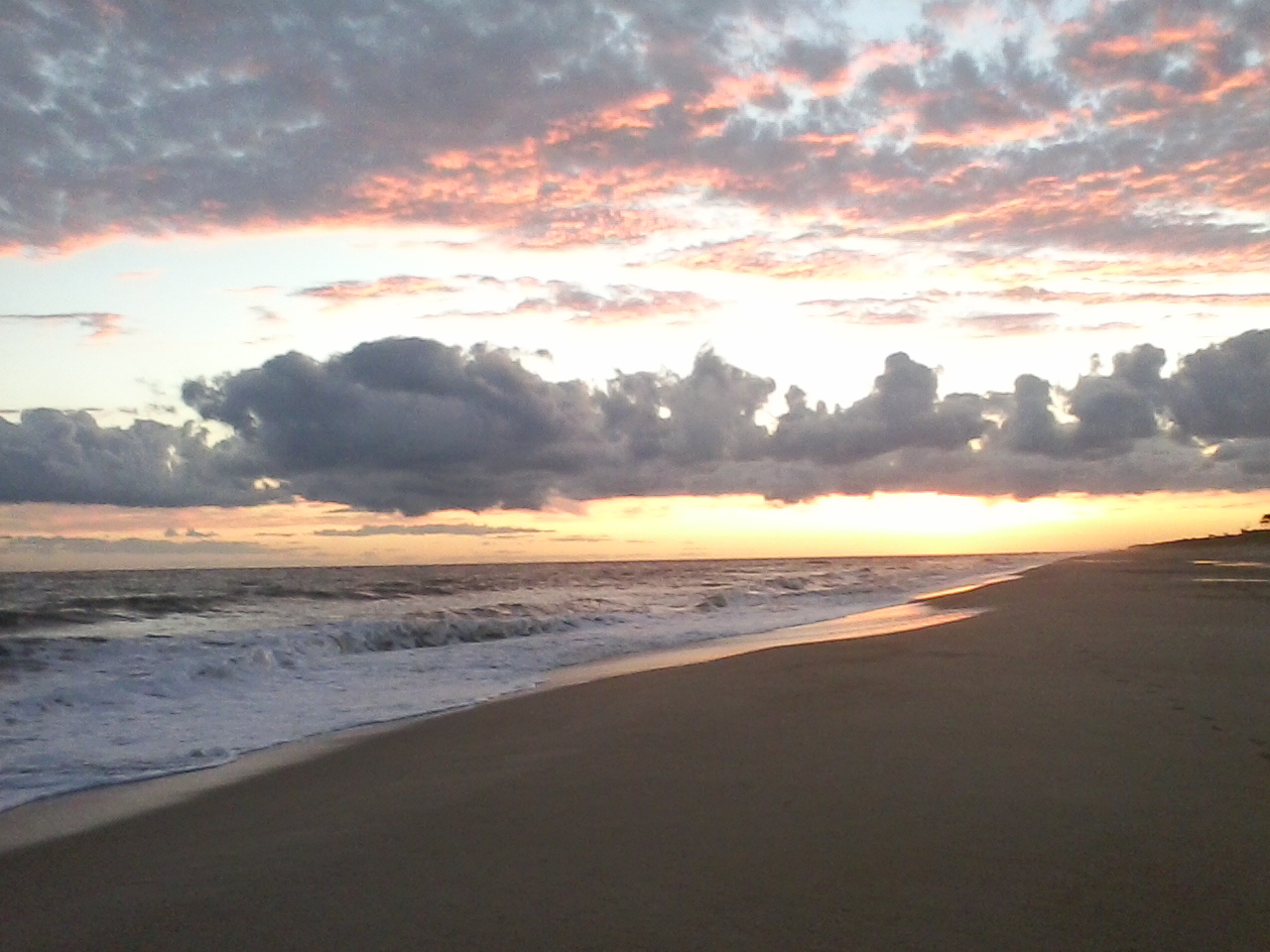 a picturesque sunset with soft waves in one of the best beaches in Costa Rica