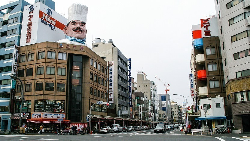 Iconic street view of Kappabashi Street with building that has a chef figurine on it.