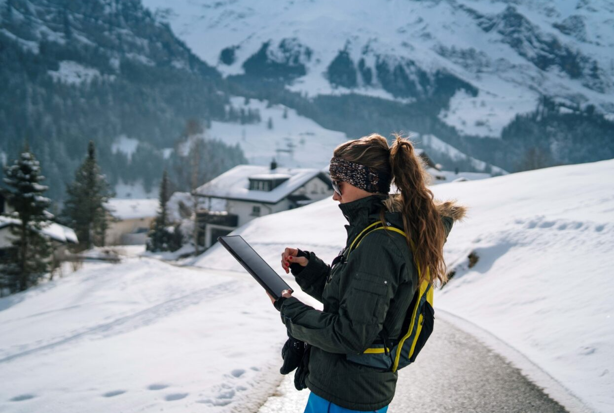 A person standing on a snowy road looking at a tabletDescription automatically generated