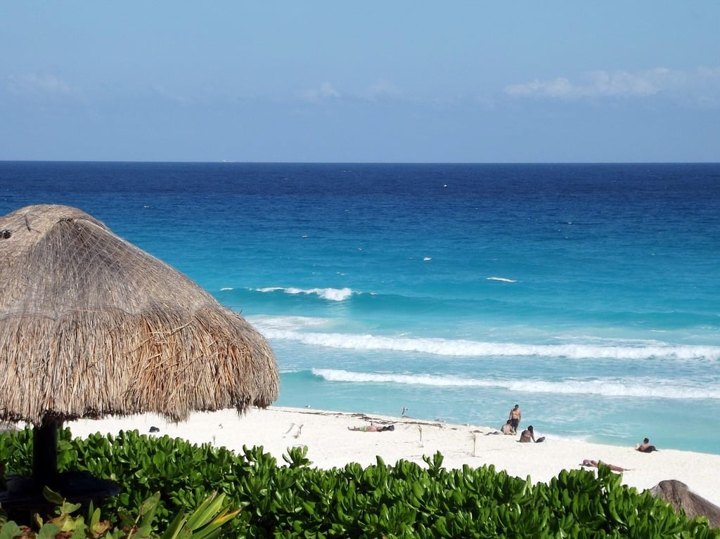 People soaking up the sun at the beach of Playa Delfines in Cancun.