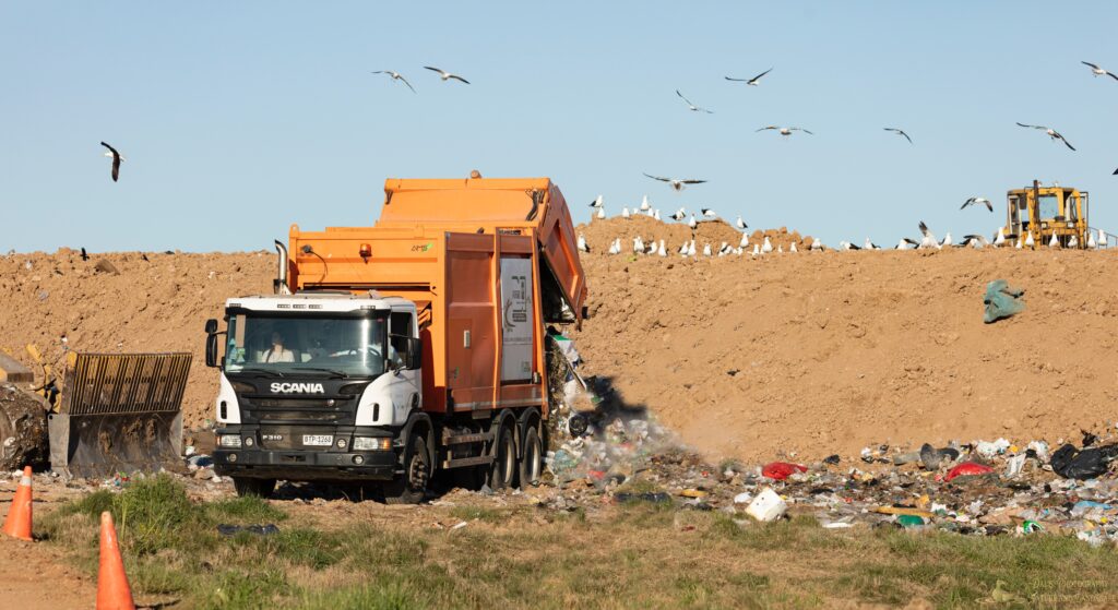 garbage truck emptying its load in a landfill