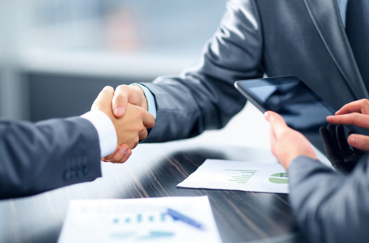 Two men shaking hands after a business investment deal