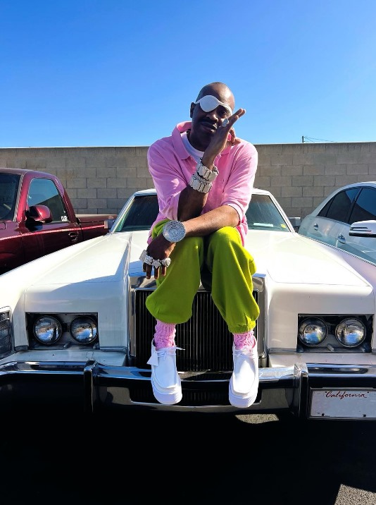 Slick Rick sitting on a rolls royce