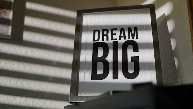 A framed sign with the words "dream big" in elegant bold font.