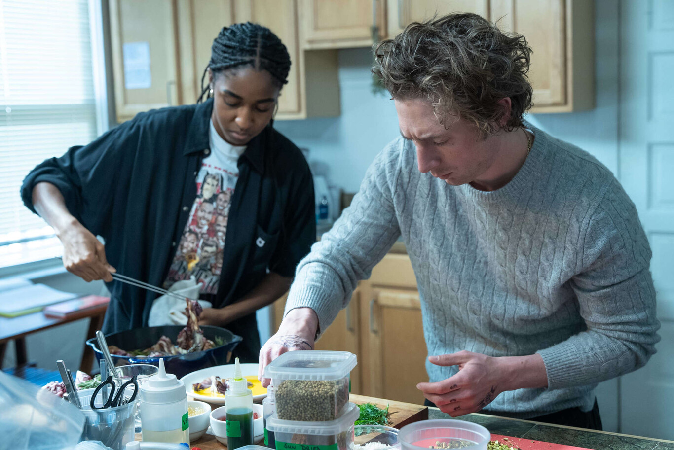 Carmy (Jeremy Allen White) y Sydney (Ayo Edebiri) cocinan juntos en la cocina de Carmy en la segunda temporada de The Bear.