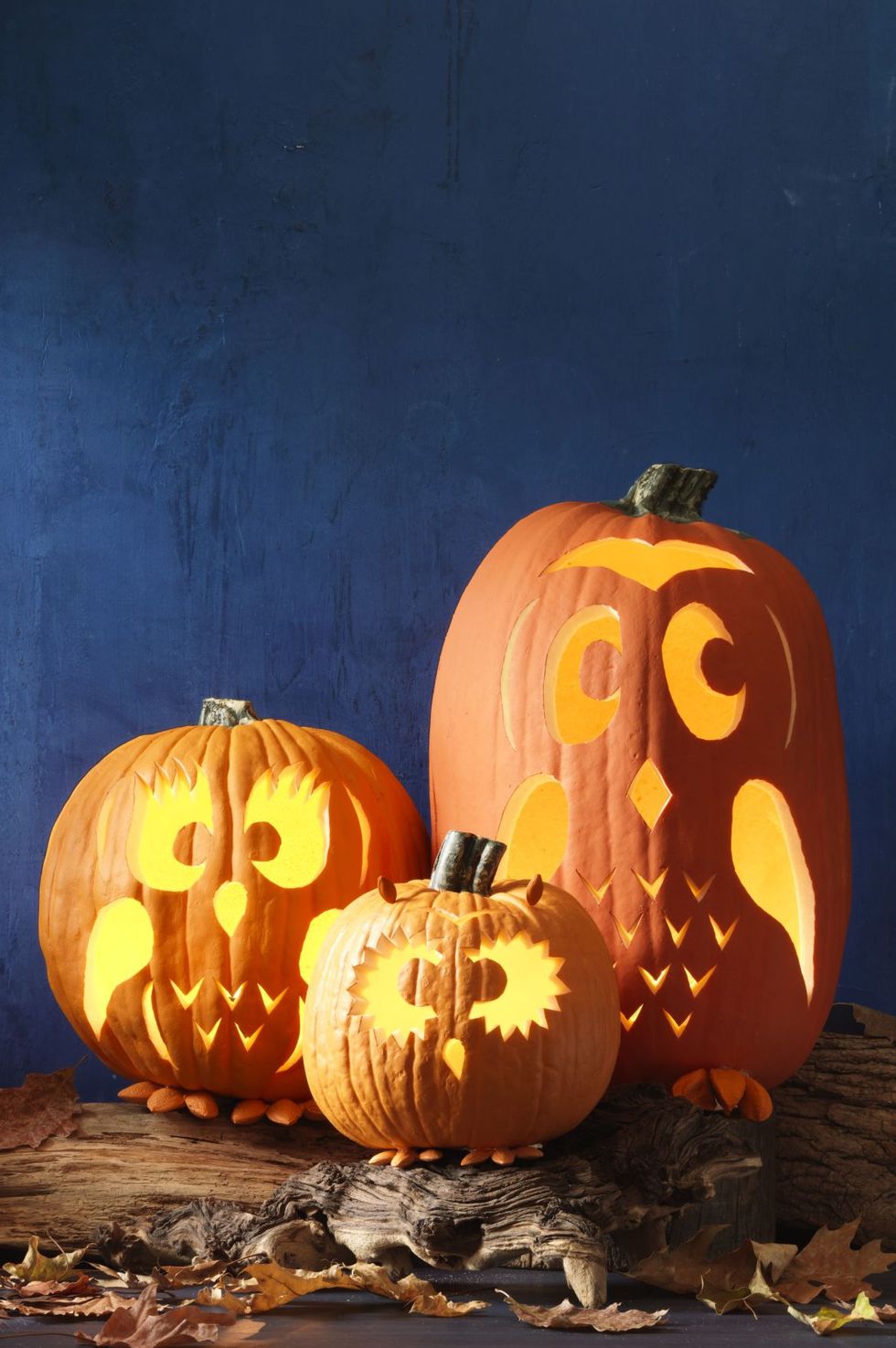 pumpkin carving ideas, three pumpkins in different sizes carved to look like owls